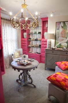 a living room filled with furniture and a chandelier hanging from the ceiling over a table