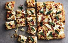 several square pieces of pizza with cheese and herbs