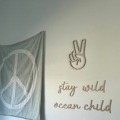 a peace sign hanging on the wall next to a green flag with words written below it