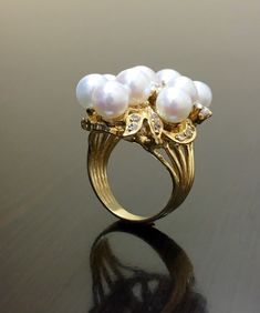 DeKara Designs Collection Beautiful Art Deco/Vintage/Modern Style Halo Diamond Pearl Cocktail Ring. Metal- 14K Yellow Gold, .583. Stones- Nine 6.5 MM Round Tahitian/South Sea Pearls, 20 Round Diamonds F-G Color SI2 Clarity 0.72 Carats. A handmade truly magnificent 14K Yellow Gold Pearl Diamond Ring. There is a beautiful cluster pearl ring with diamonds that are dazzling surrounding the pearls. This ring is perfect! The diamonds are stunning and make the pearls pop! You have a total of nine pearl Luxury White Cluster Pearl Ring, Vintage Multi-stone Pearl Ring For Anniversary, Vintage Gold Multi-stone Cluster Ring, Vintage Multi-stone Pearl Ring For Formal Events, Vintage Multi-stone Pearl Ring For Formal Occasions, Luxury Handmade Pearl Ring For Wedding, Handmade Gold Diamond Ring Elegant Style, Unique High Luster Jewelry For Wedding, Unique High Luster Wedding Jewelry