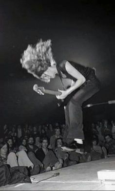 a man on a skateboard doing a trick in front of an audience at a concert