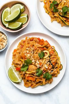 three plates of food on a table with limes, peanuts and other foodstuffs