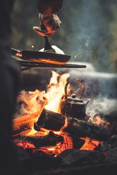 a person is cooking food over an open fire