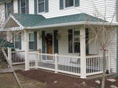 a white house with green shutters on the front porch