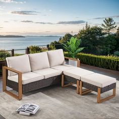 an outdoor patio furniture set with a magazine laying on the ground next to it and water in the background