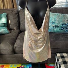 a mannequin wearing a gold top in front of a couch