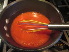 the sauce is being stirred with whisks in a pot on the stove top