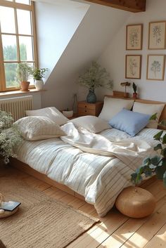 an unmade bed sitting in a bedroom next to a window with potted plants