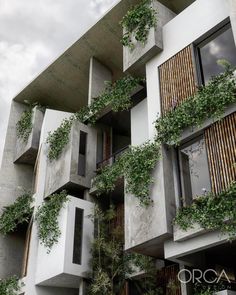 an apartment building with plants growing on the balconies