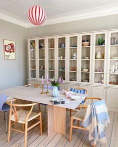 a dining room table with chairs and a china cabinet in the backround area