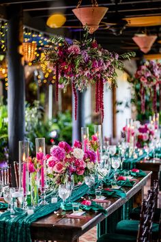 a long table is set with green linens and pink flowers