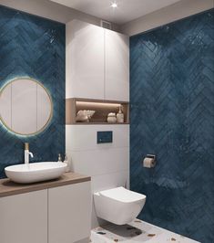 a bathroom with blue and white tiles on the walls, a round mirror above the toilet