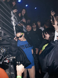 a group of people standing next to each other in front of a camera and some holding cell phones