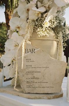 a table topped with a vase filled with white flowers