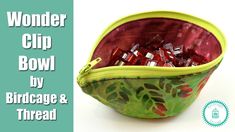 a green and red bag filled with candy sitting on top of a white table next to the words wonder clip bowl by birdcage & thread