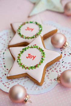 two decorated cookies sitting on top of a doily