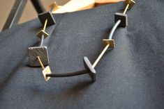 Necklace from the QUADRO line, adjustable in length, composed of squares in brass and slate of various sizes, with alternating cord, brass tubular elements, and rubber. You can choose the preferred length thanks to the sliding closure at the back. The contrast between gold and black colors makes it a unique, original, and highly versatile accessory. Entirely handmade, made in Italy. The slate used comes from processing waste from companies in the province of Genoa, recovered, recycled, and rewor Modern Necklaces With Adjustable Rectangular Links, Modern Necklace With Adjustable Rectangular Links, Artisan Adjustable Rectangular Necklace, Handmade Rectangular Brass Necklace, Artistic Black Adjustable Necklace, Alternative Jewelry, Black Stone, Adjustable Necklace, Minimalist Necklace