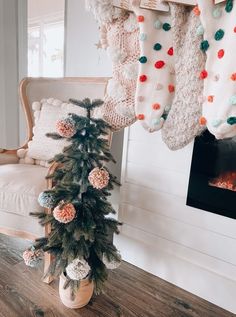 a small christmas tree sitting on top of a wooden table in front of a fireplace