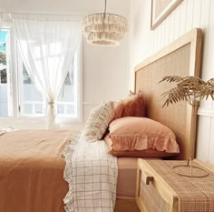 a bed sitting in a bedroom next to a window with curtains on the windowsill