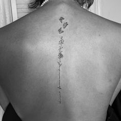 the back of a woman's neck with flowers on it