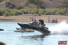 a jet ski being pulled by a boat on the water with people in the background