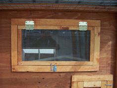 the inside of a chicken coop with wooden walls and metal bars on the windowsill