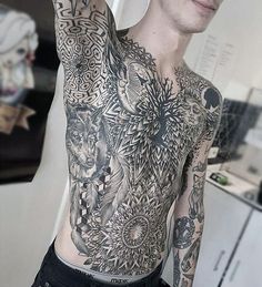 a man with lots of tattoos on his chest and arms is posing for the camera