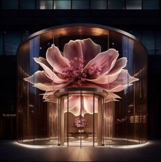 an artistic display in the middle of a building with large pink flowers on it's side