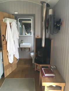 a small bathroom with wood flooring and white towels hanging on the wall next to it