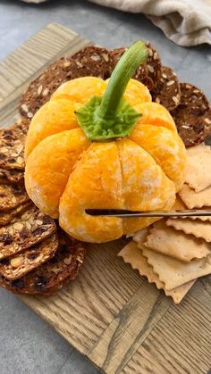 a wooden board topped with oranges and crackers