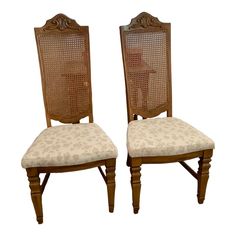 two wooden chairs with floral upholstered back and seat cushions, side by side