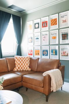 a brown leather couch sitting in front of a window