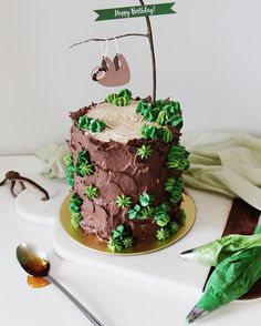 a birthday cake decorated with green leaves and a slotty on top