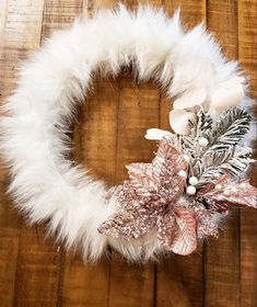 a white wreath with silver and pink decorations