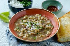 a bowl of soup with bread on the side