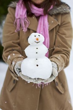 a woman holding a snowman in her hands with the words raising written on it