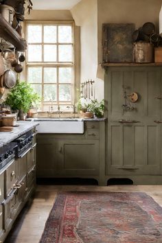 an old fashioned kitchen with green cabinets and rug