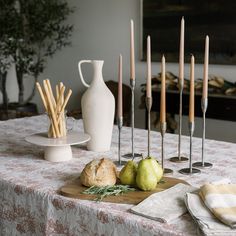 the table is set with bread, pears and candles