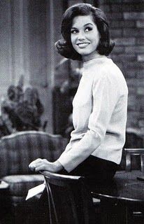 a black and white photo of a woman sitting on a chair