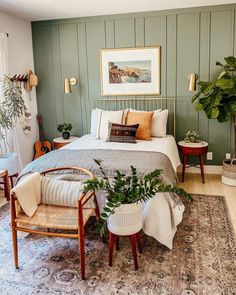 a bed room with a neatly made bed next to a chair and potted plant