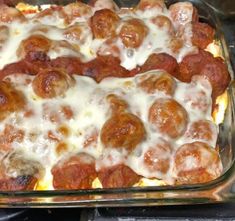 a glass casserole dish filled with meatballs and cheese covered in melted cheese