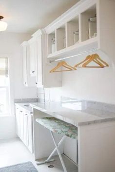 a kitchen with white cabinets and an ironing board