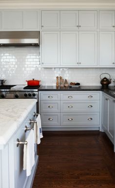 a kitchen with white cabinets and black counter tops