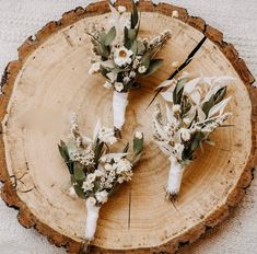 three bouquets of flowers are sitting on a piece of wood