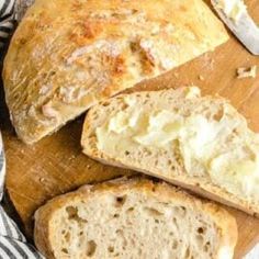 two loaves of bread sitting on top of a wooden cutting board