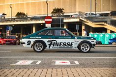 a green and white race car driving down the street