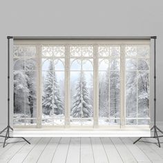 an empty room with snow covered trees outside the window