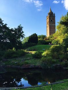 there is a tall tower with a clock on it in the middle of a park