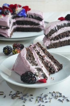 two plates with slices of cake and berries on them