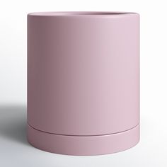 a pink cup sitting on top of a white table